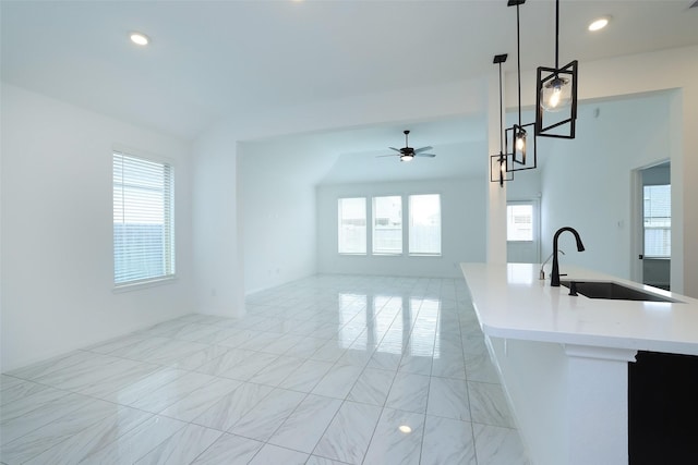 kitchen featuring open floor plan, decorative light fixtures, light countertops, a sink, and recessed lighting