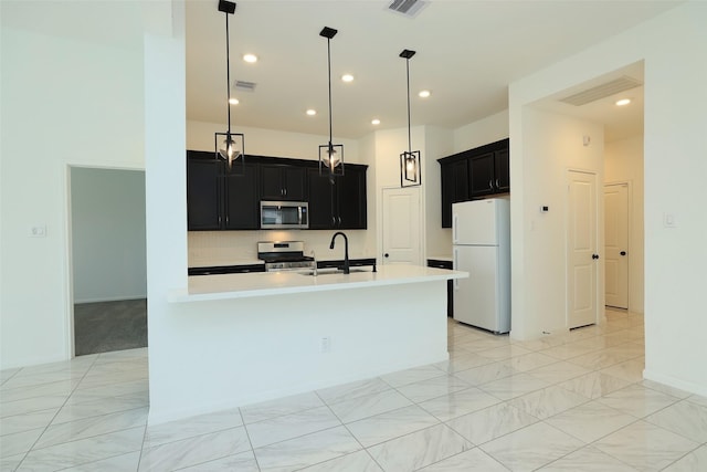 kitchen with decorative light fixtures, visible vents, light countertops, appliances with stainless steel finishes, and dark cabinets