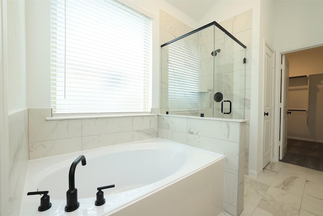 bathroom featuring marble finish floor, a spacious closet, a shower stall, and a bath