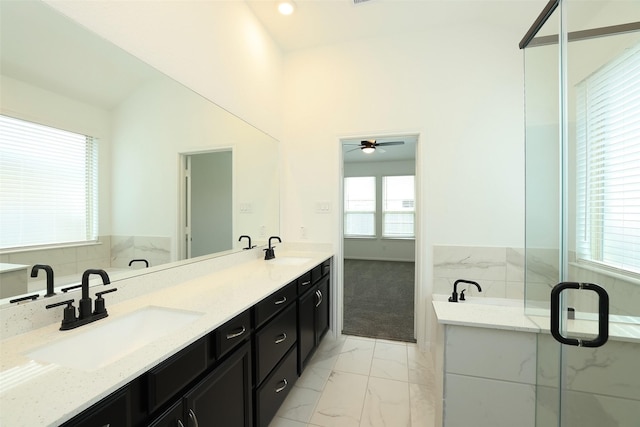 bathroom featuring marble finish floor, double vanity, a sink, and a bath