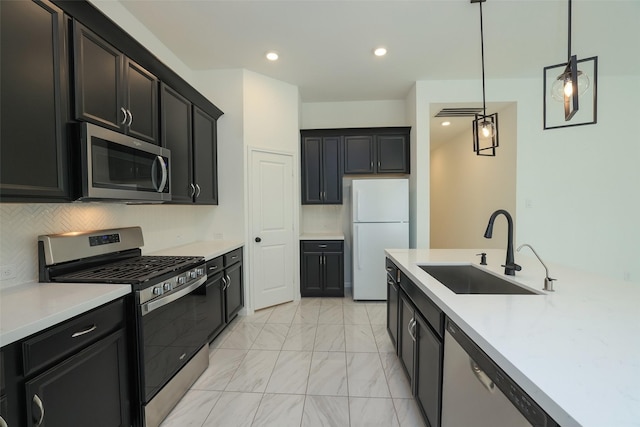 kitchen featuring recessed lighting, a sink, appliances with stainless steel finishes, tasteful backsplash, and decorative light fixtures