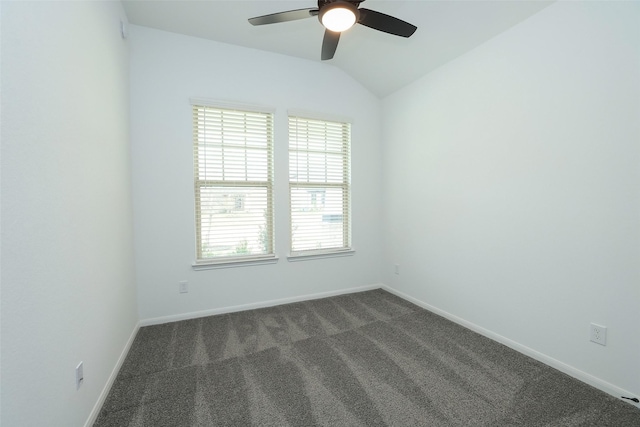 empty room featuring dark colored carpet, ceiling fan, lofted ceiling, and baseboards