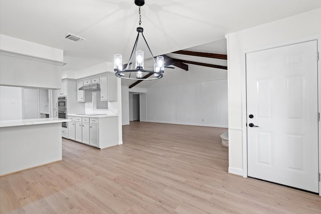 kitchen featuring a notable chandelier, white cabinets, decorative light fixtures, stainless steel double oven, and light wood-type flooring