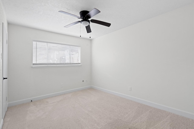 carpeted spare room featuring ceiling fan and a textured ceiling