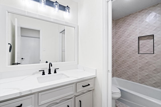 full bathroom featuring vanity, tiled shower / bath, and toilet