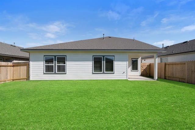 rear view of house featuring a yard and a patio area