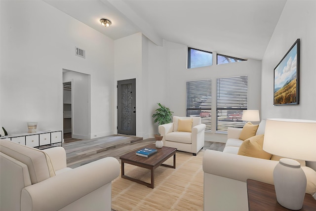 living room with high vaulted ceiling, light hardwood / wood-style floors, and beamed ceiling