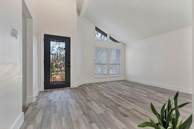 entryway featuring beamed ceiling, high vaulted ceiling, and light hardwood / wood-style flooring