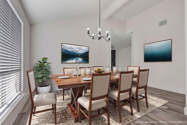 dining room with wood-type flooring, vaulted ceiling with beams, and a chandelier