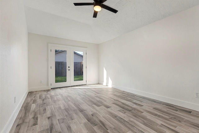 spare room featuring french doors, ceiling fan, light hardwood / wood-style floors, and a textured ceiling