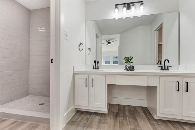 bathroom with vanity, a tile shower, and ceiling fan