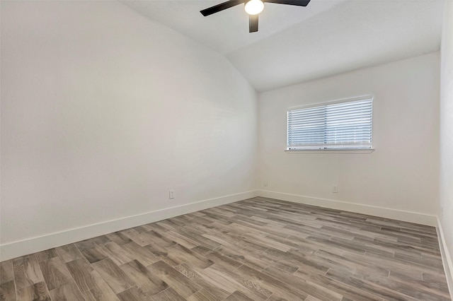 empty room featuring vaulted ceiling, light hardwood / wood-style floors, and ceiling fan