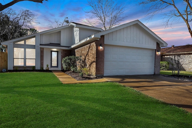 view of front of home with a garage and a lawn