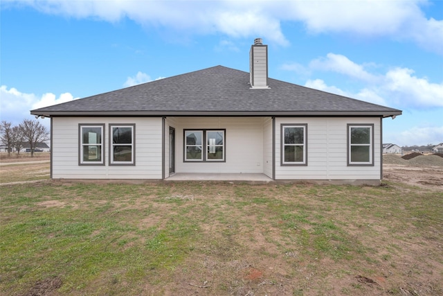 rear view of property with a lawn and a patio