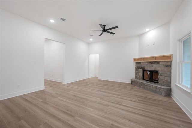 unfurnished living room with light hardwood / wood-style flooring, a fireplace, and ceiling fan