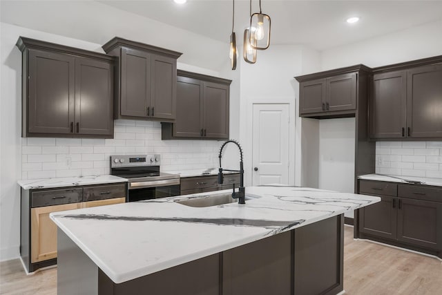 kitchen featuring sink, light hardwood / wood-style flooring, a kitchen island with sink, and stainless steel range with electric stovetop