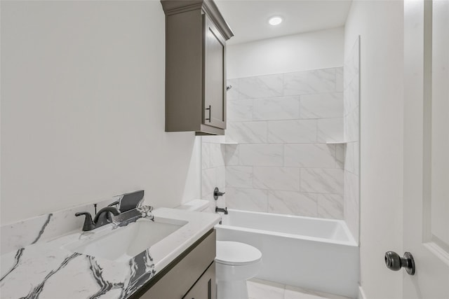 full bathroom featuring tiled shower / bath, vanity, and toilet