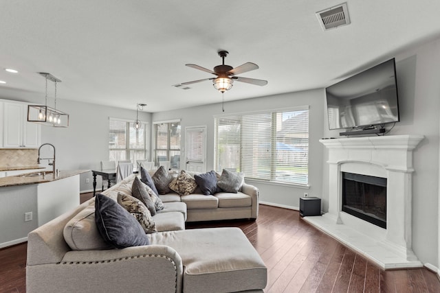 living room with sink, dark wood-type flooring, and ceiling fan