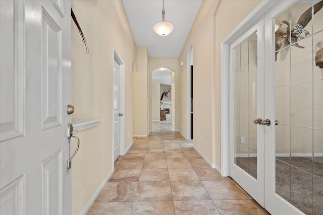 corridor with light tile patterned floors and french doors