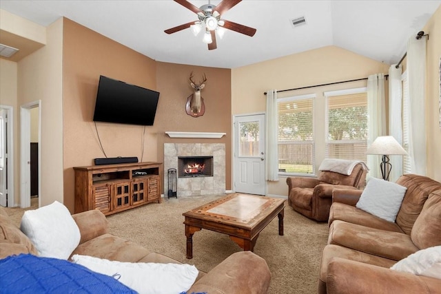 carpeted living room featuring ceiling fan, lofted ceiling, and a tile fireplace