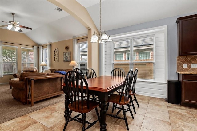 dining space with lofted ceiling, ceiling fan with notable chandelier, and light tile patterned floors