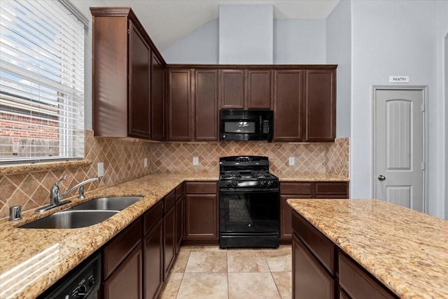 kitchen with dark brown cabinetry, sink, light stone countertops, decorative backsplash, and black appliances