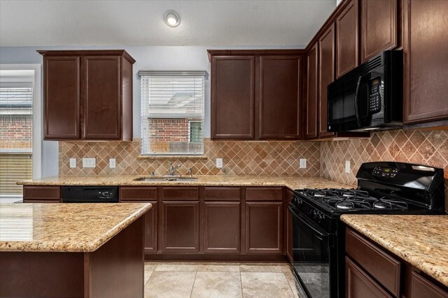 kitchen with sink, decorative backsplash, a wealth of natural light, and black appliances