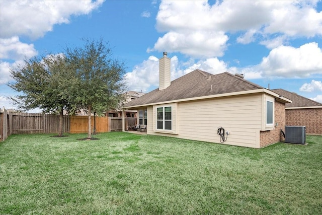 rear view of property with cooling unit and a lawn