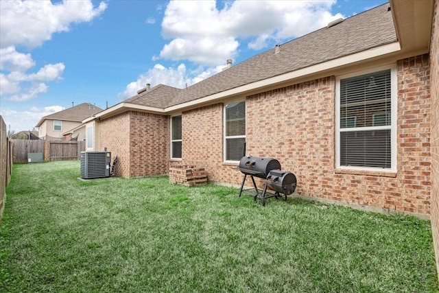 back of property featuring cooling unit and a yard