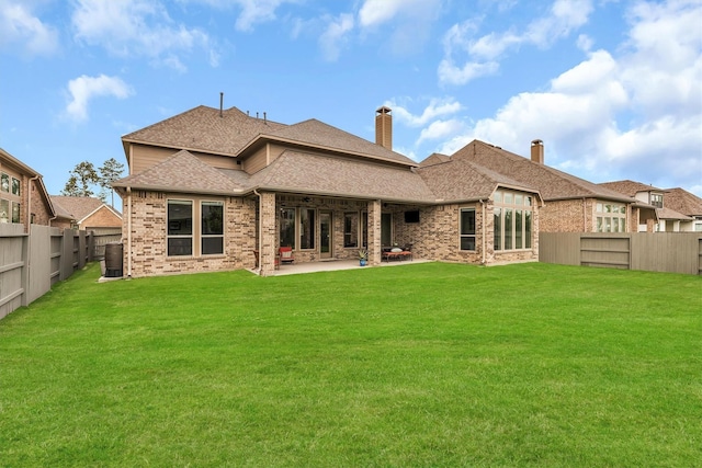 back of house featuring a lawn and a patio area