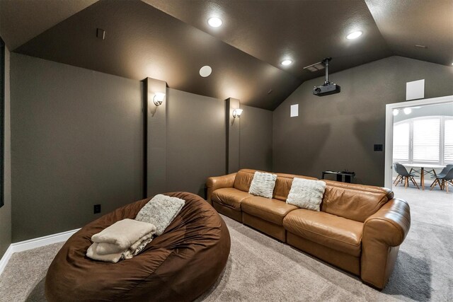 carpeted home theater room with vaulted ceiling