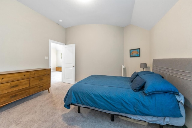 bedroom with light colored carpet and vaulted ceiling