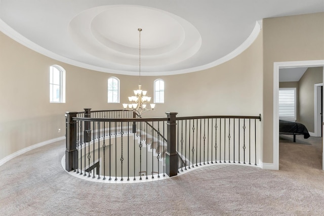 hall with plenty of natural light, carpet flooring, and a notable chandelier