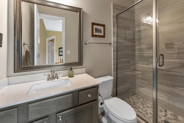 bathroom with vanity, toilet, and a shower with shower door