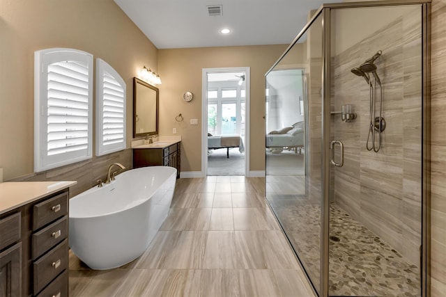 bathroom featuring vanity and independent shower and bath