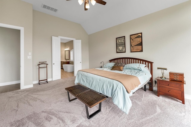 carpeted bedroom with ceiling fan, lofted ceiling, and ensuite bathroom