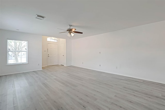 empty room with ceiling fan and light hardwood / wood-style flooring