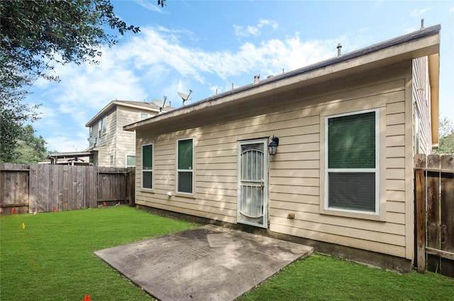 rear view of house with a yard and a patio