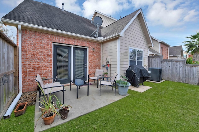 rear view of house with a yard, a patio area, and central air condition unit