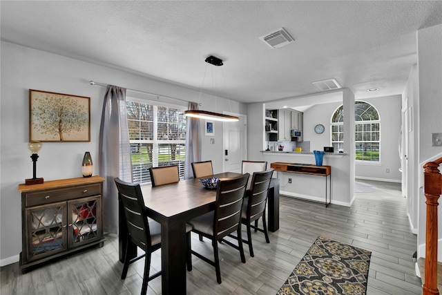 dining room featuring hardwood / wood-style flooring and a textured ceiling