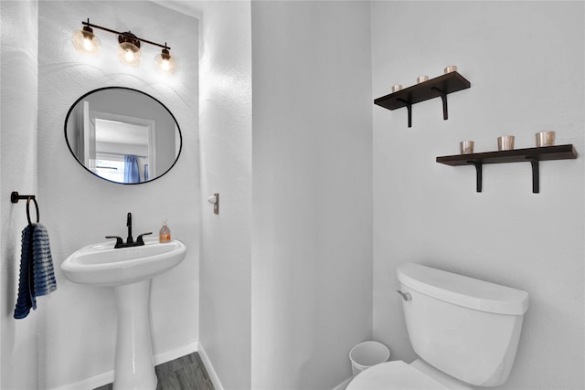 bathroom featuring hardwood / wood-style flooring and toilet