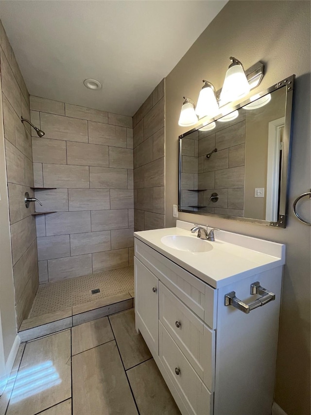 bathroom with vanity and a tile shower