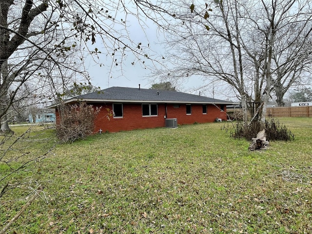 rear view of property featuring cooling unit and a yard