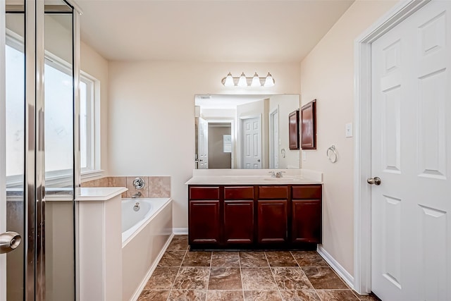 bathroom featuring a garden tub, vanity, and baseboards