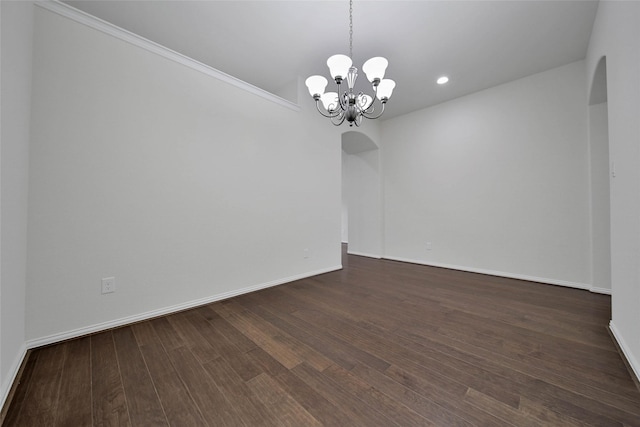 empty room with an inviting chandelier and dark hardwood / wood-style flooring