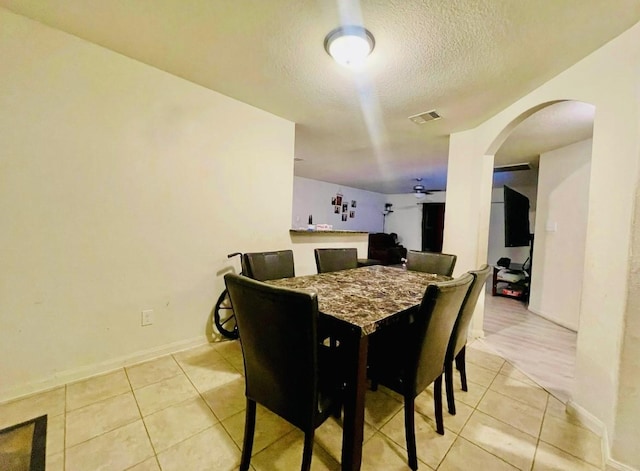 dining space with light tile patterned floors and a textured ceiling