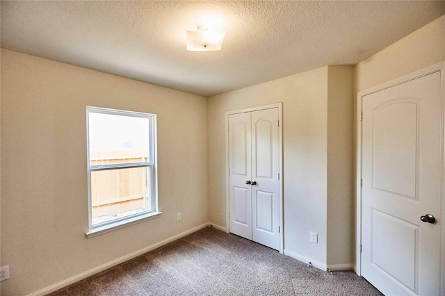 unfurnished bedroom with a closet, carpet, and a textured ceiling