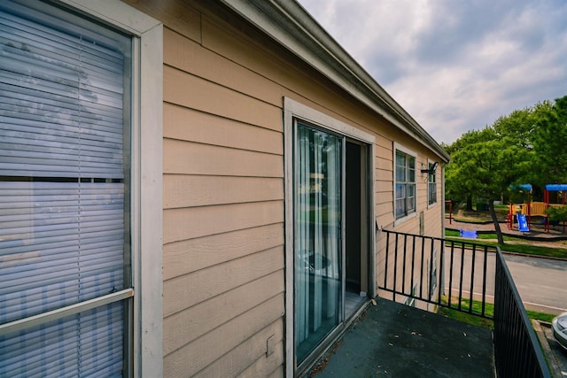 view of side of home with a playground and a balcony