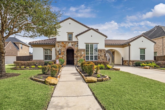 mediterranean / spanish house featuring a front yard