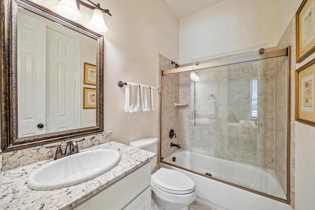 full bathroom with bath / shower combo with glass door, vanity, and toilet